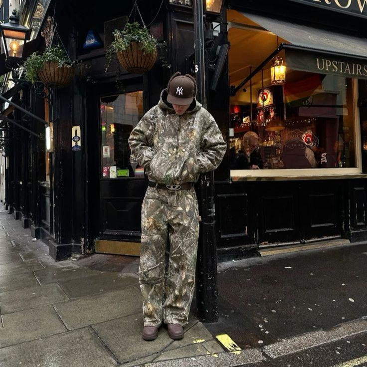 Hayden unisex hoodie with a camouflage pattern, zip closure, and a comfortable, relaxed fit.