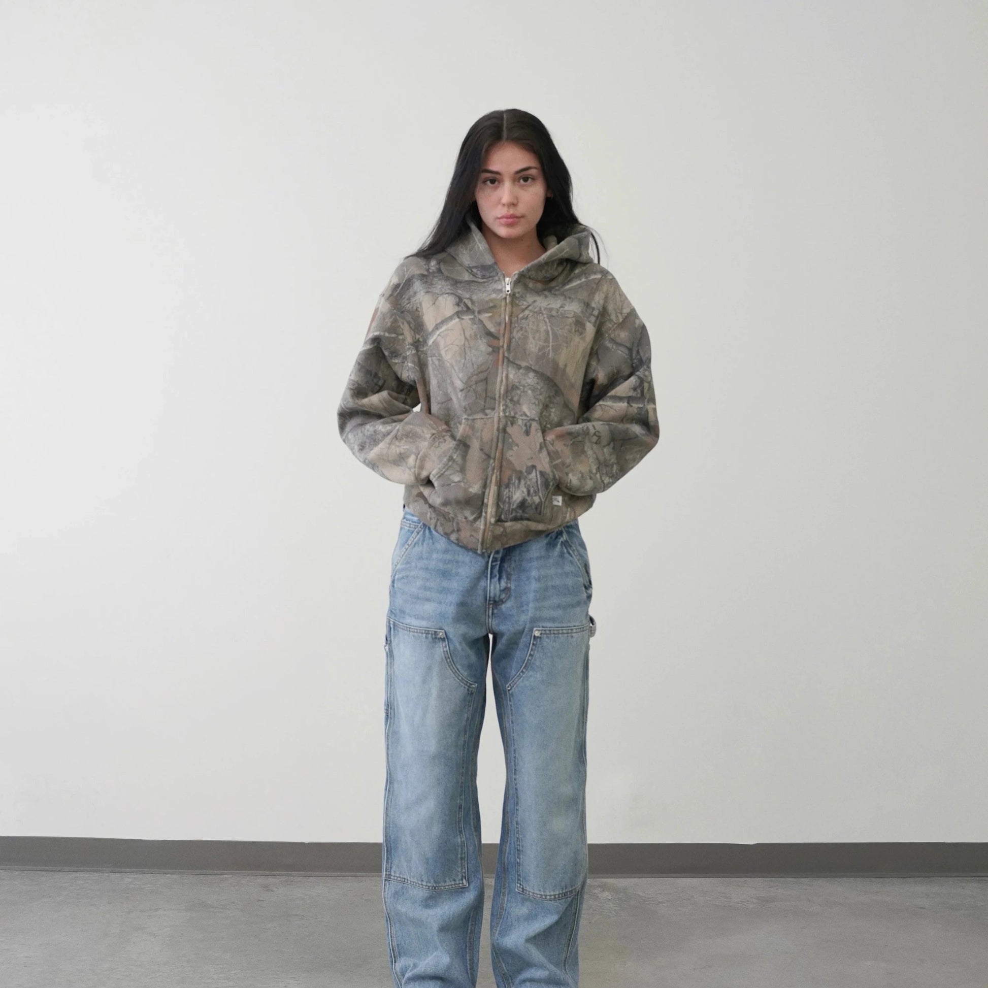 Hayden unisex hoodie with a camouflage pattern, zip closure, and a comfortable, relaxed fit.