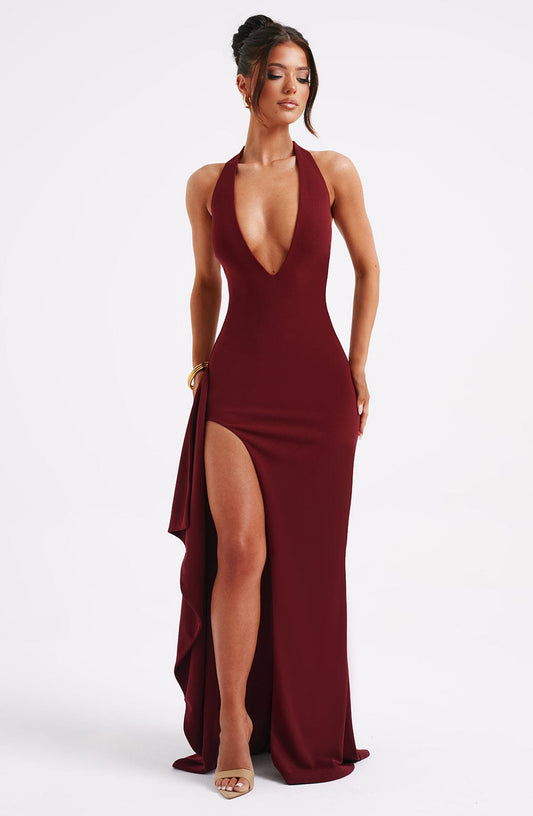 Maya elegant halter neck maxi dress with a flowing skirt and a subtle slit, in a solid color.